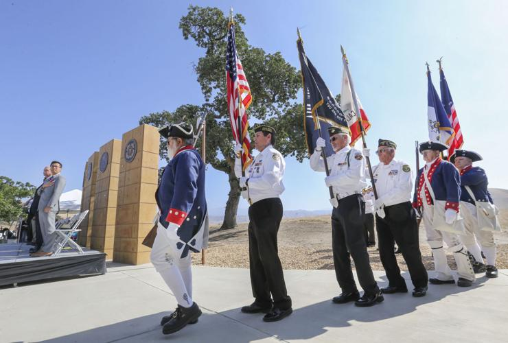 Color guard carrying flags at a cemetery ceremony