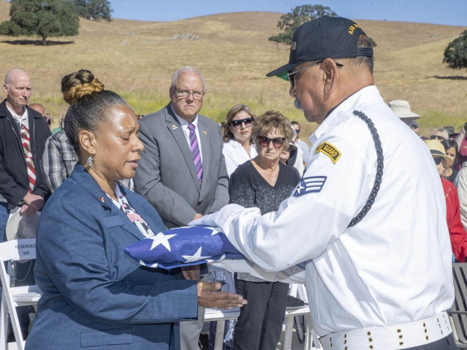 Honor guard member presenting a folded flag
